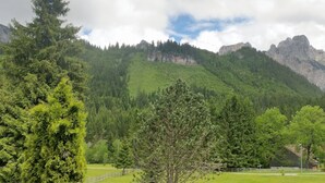 Eine Berglandschaft mit einem Holzbau im Vordergrund.