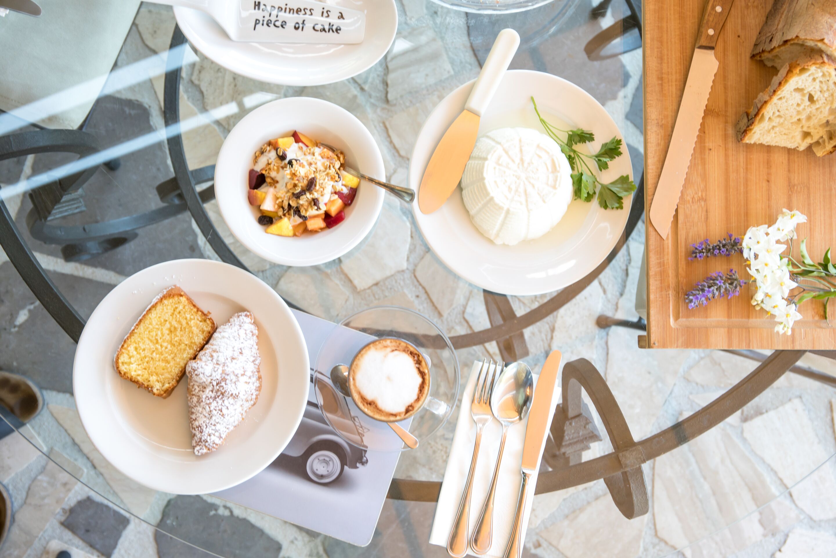 Ein Tisch mit verschiedenen Speisen, Besteck und einem Schild mit der Aufschrift 'Happiness is a piece of cake'.