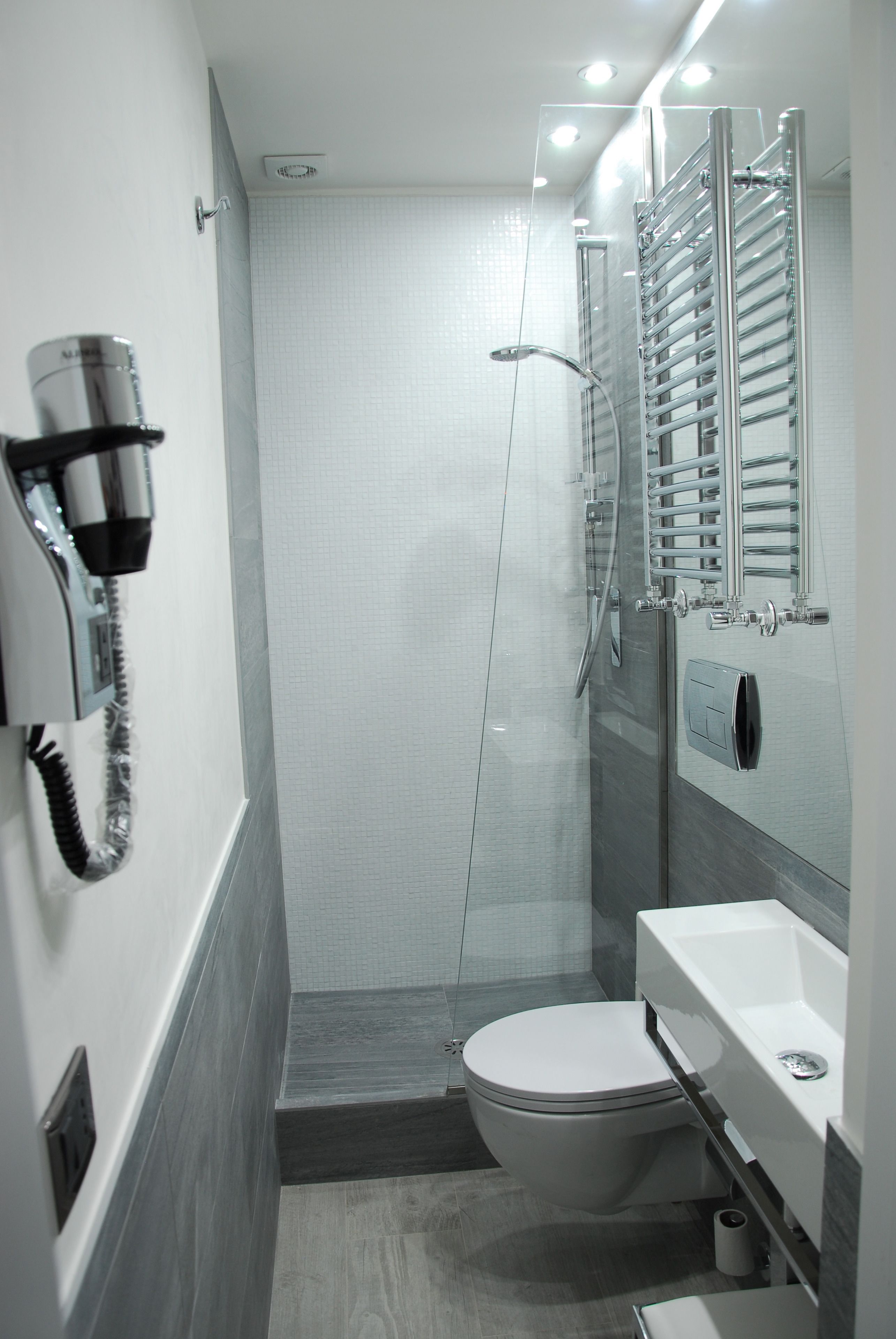 A modern bathroom with a toilet, sink, and shower.