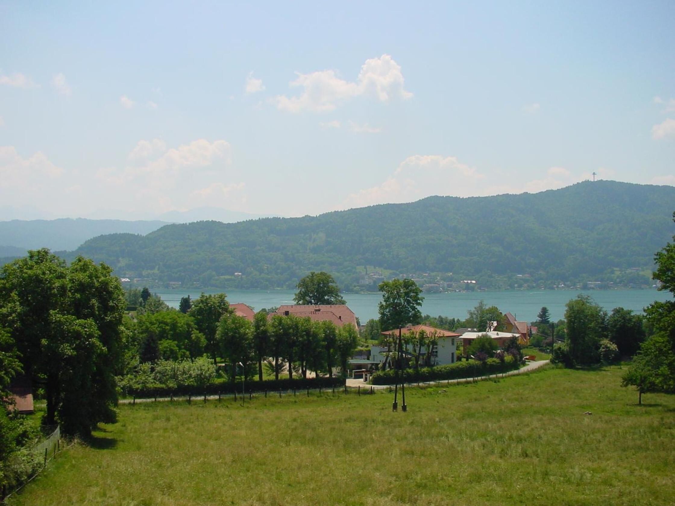 Un paisaje rural con un lago, casas y árboles.