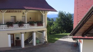 Un edificio con balcón, escaleras y vistas a las montañas.
