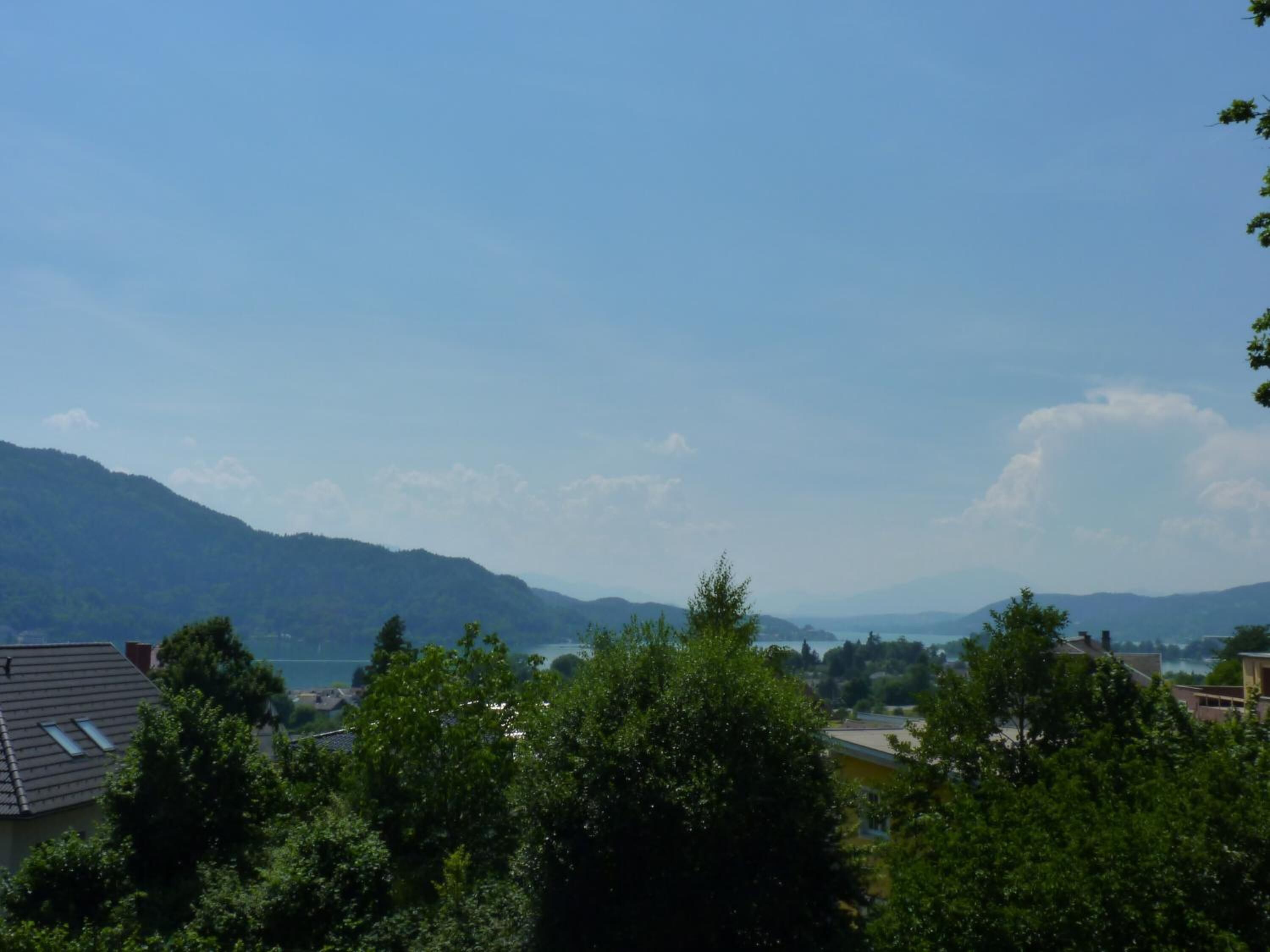 A residential area with houses, trees, and mountains in the background.