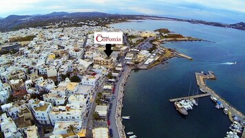 Vista aérea de un pueblo costero con un hotel destacado llamado "Hotel Coronis", señalado con una flecha.