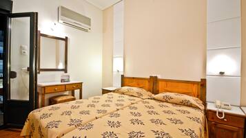 A bedroom with a bed, bedside table, and a mirror.