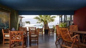 A wooden-floored terrace with wooden chairs and a table, overlooking a pool and the sea. - Charm Beach Hotel - All Inclusive (Bodrum)