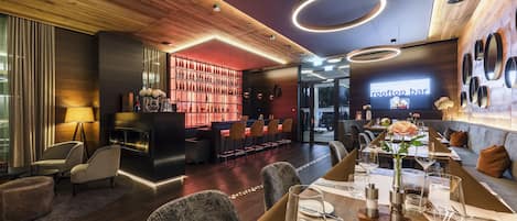 Un restaurante moderno con barra, techo de madera y una distribución de asientos acogedora.