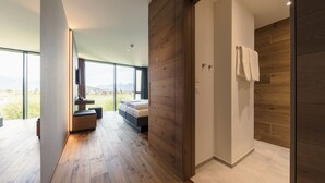 A modern bedroom with a large window, a bed, and a wooden floor. - Hotel Kommod (Ruggell)