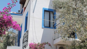 A two-story building with a balcony, a large potted plant, and a sign that reads "HOTEL TERRACE." - Lizo Hotel (Kas)