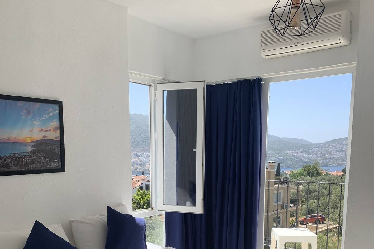 Un dormitorio con una cama grande, vistas a la ciudad y un balcón.