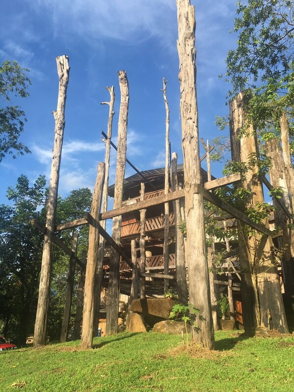 A wooden structure with a balcony, surrounded by trees. - Mirador Prendas (Las Horquetas)