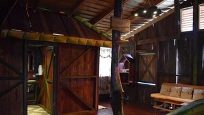 Un intérieur rustique en bois, avec un banc en bois et un luminaire suspendu.