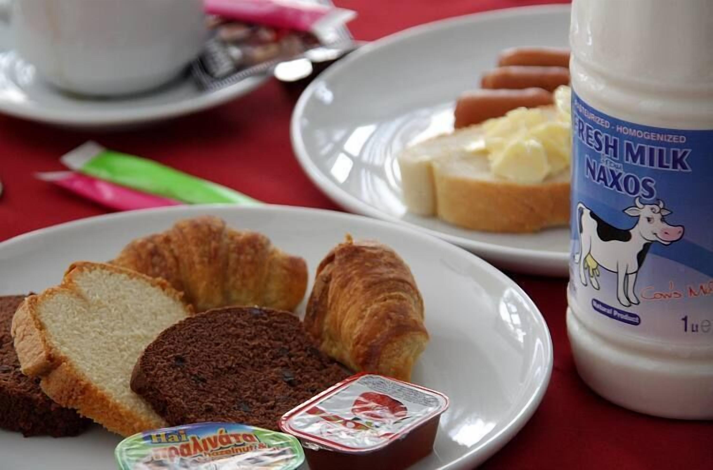 A breakfast setting with bread, butter, and a bottle of fresh milk.