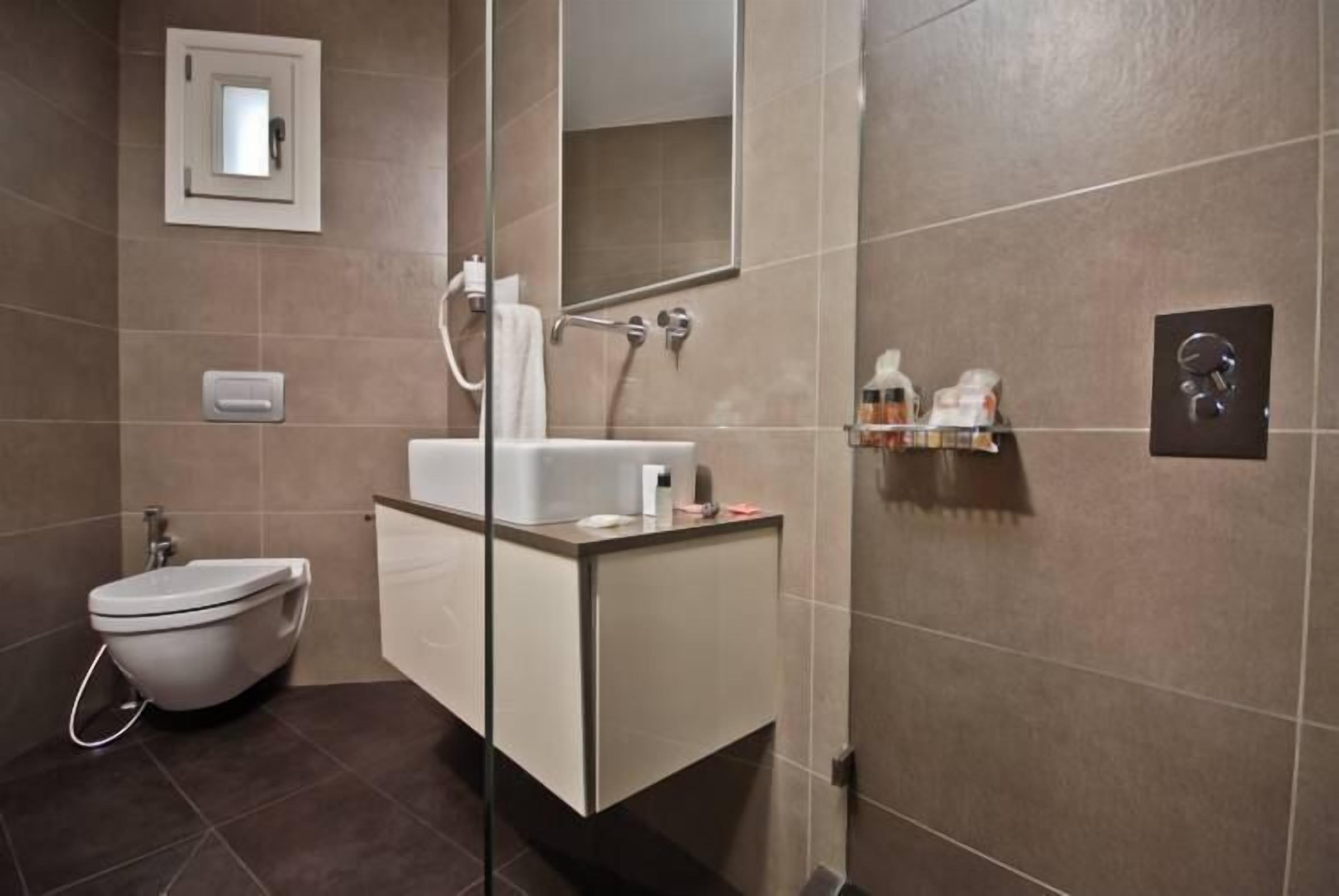Un baño moderno con inodoro, lavabo y ducha.
