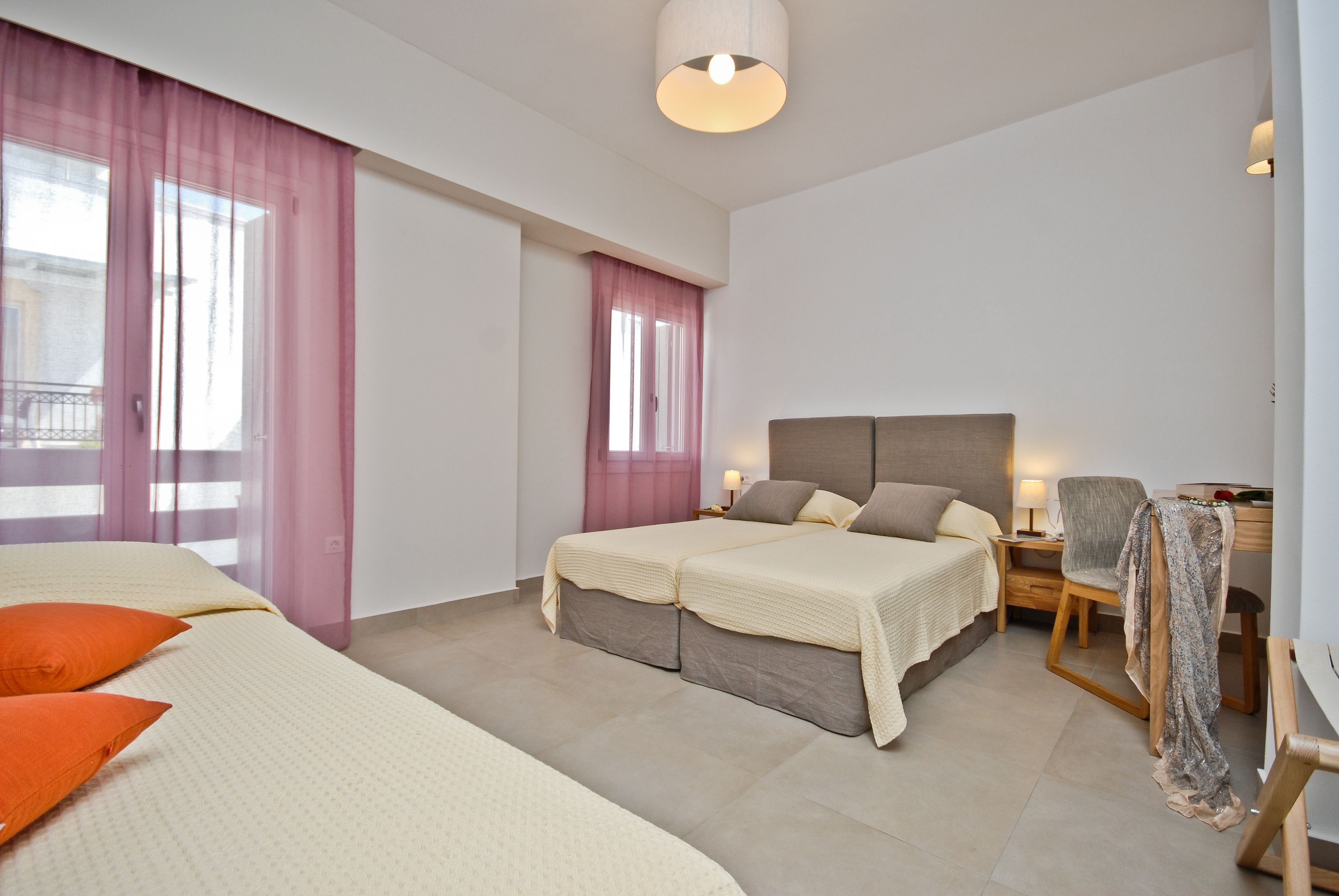 Quarto de hotel moderno com uma cama grande, uma escrivaninha e uma cadeira.