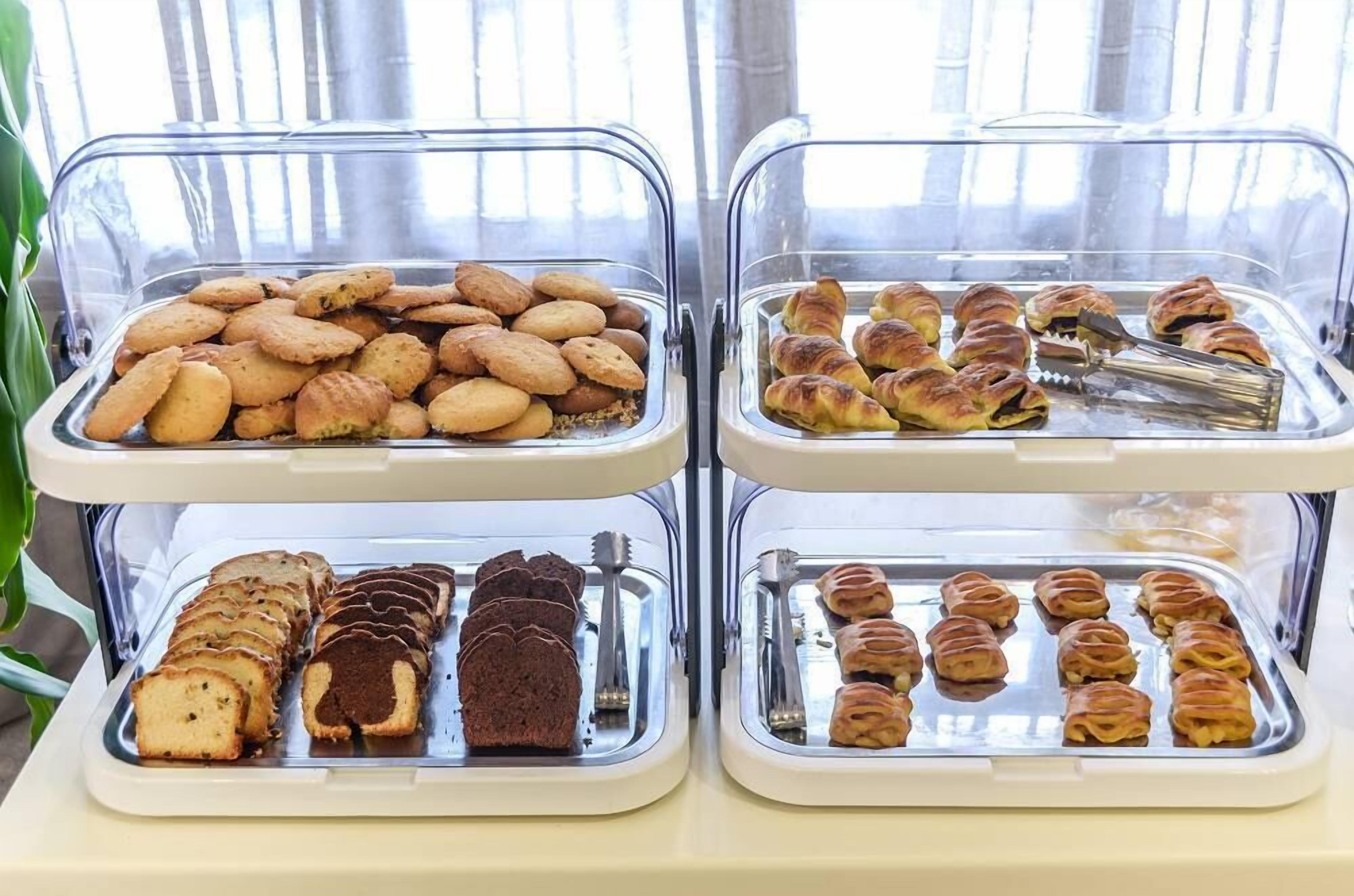 Een buffet met diverse gebakken producten, waaronder koekjes, gebak en brood.