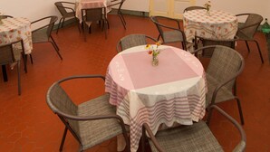 A dining area with round tables and chairs, a chandelier, and a door with glass panels. - Mengqi Hostel (Huxi)
