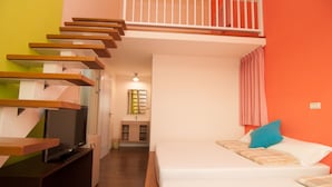 A bedroom with a bed, a TV, and a staircase leading to an upper level.