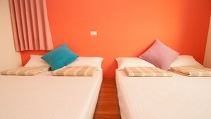 Two single beds with checkered pillows, a wooden floor, and an orange wall. - Mengqi Hostel (Huxi)