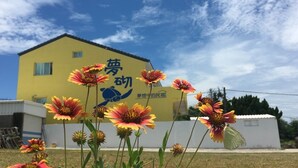 A yellow building with a sign in Chinese characters. - Mengqi Hostel (Huxi)