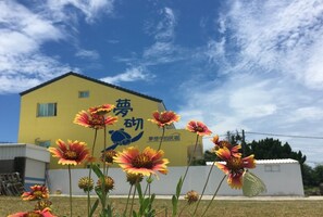 A yellow building with a sign in Chinese characters. - Mengqi Hostel (Huxi)