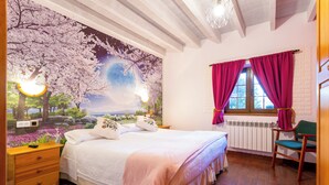 Een slaapkamer met een groot bed, een nachtkastje, een raam met gordijnen en een muurschildering van kersenbloesems.