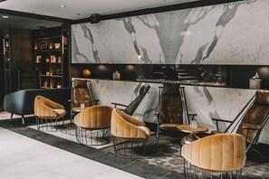 A modern interior with a marble wall, leather furniture, and a glass display case.
