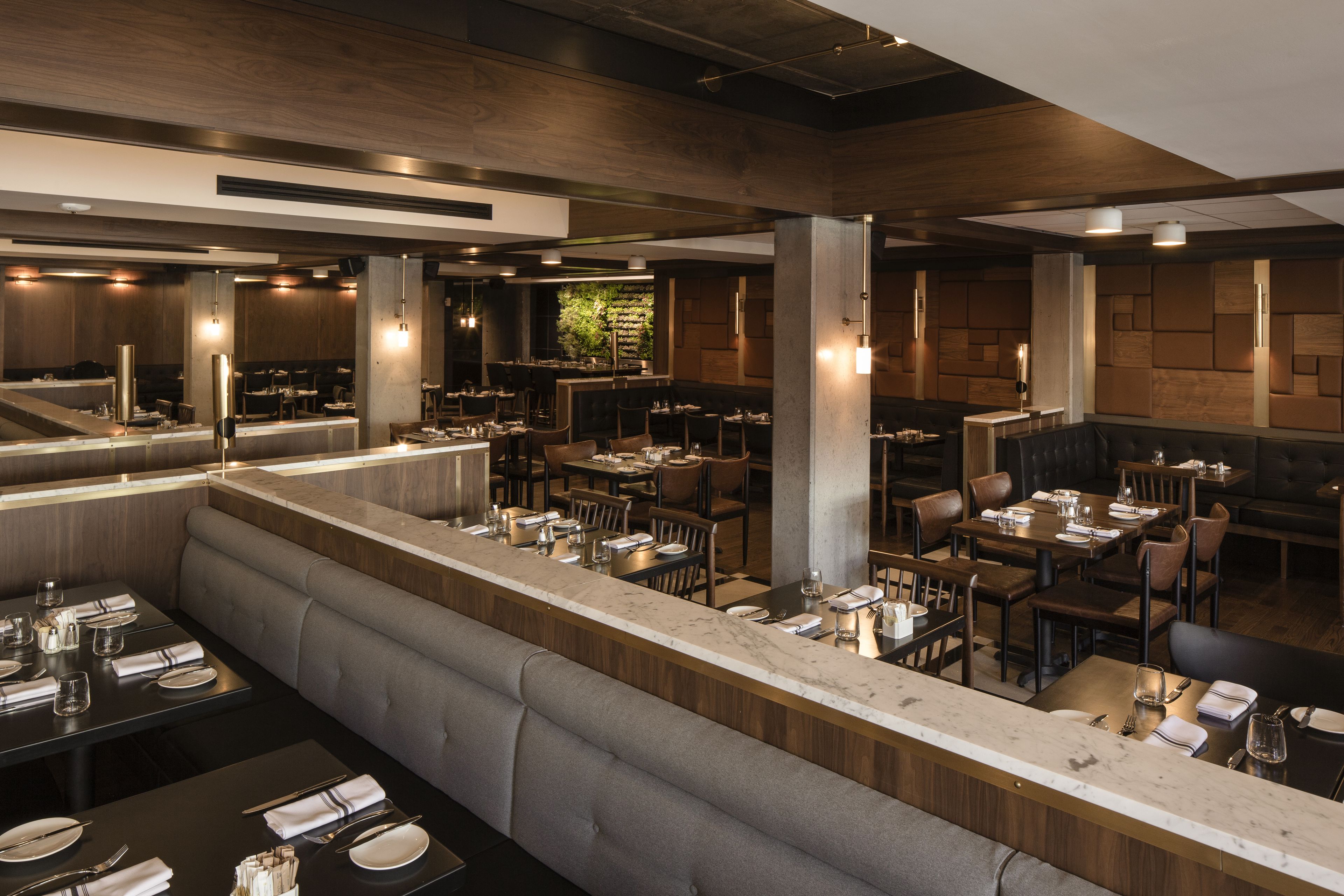 A modern restaurant with a long counter, booths, and high ceilings.