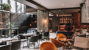 Ein modernes Interieur mit Treppe, Sitzbereichen und einer Bar.
