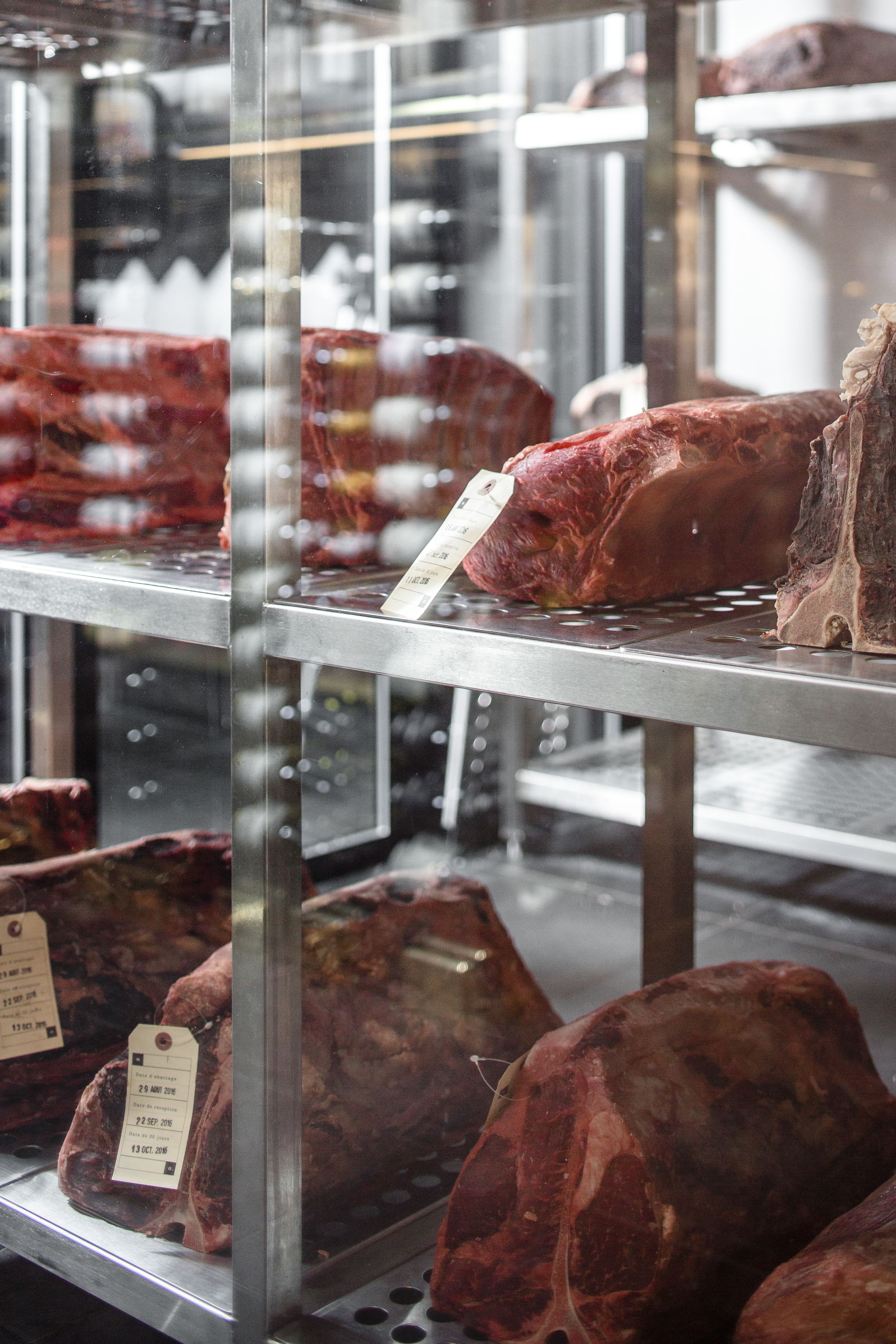 A meat display in a refrigerated case with price tags.