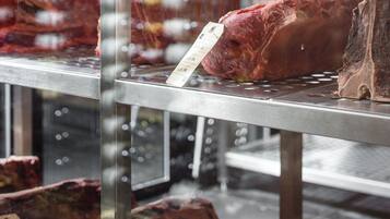 A meat display in a refrigerated case with price tags.