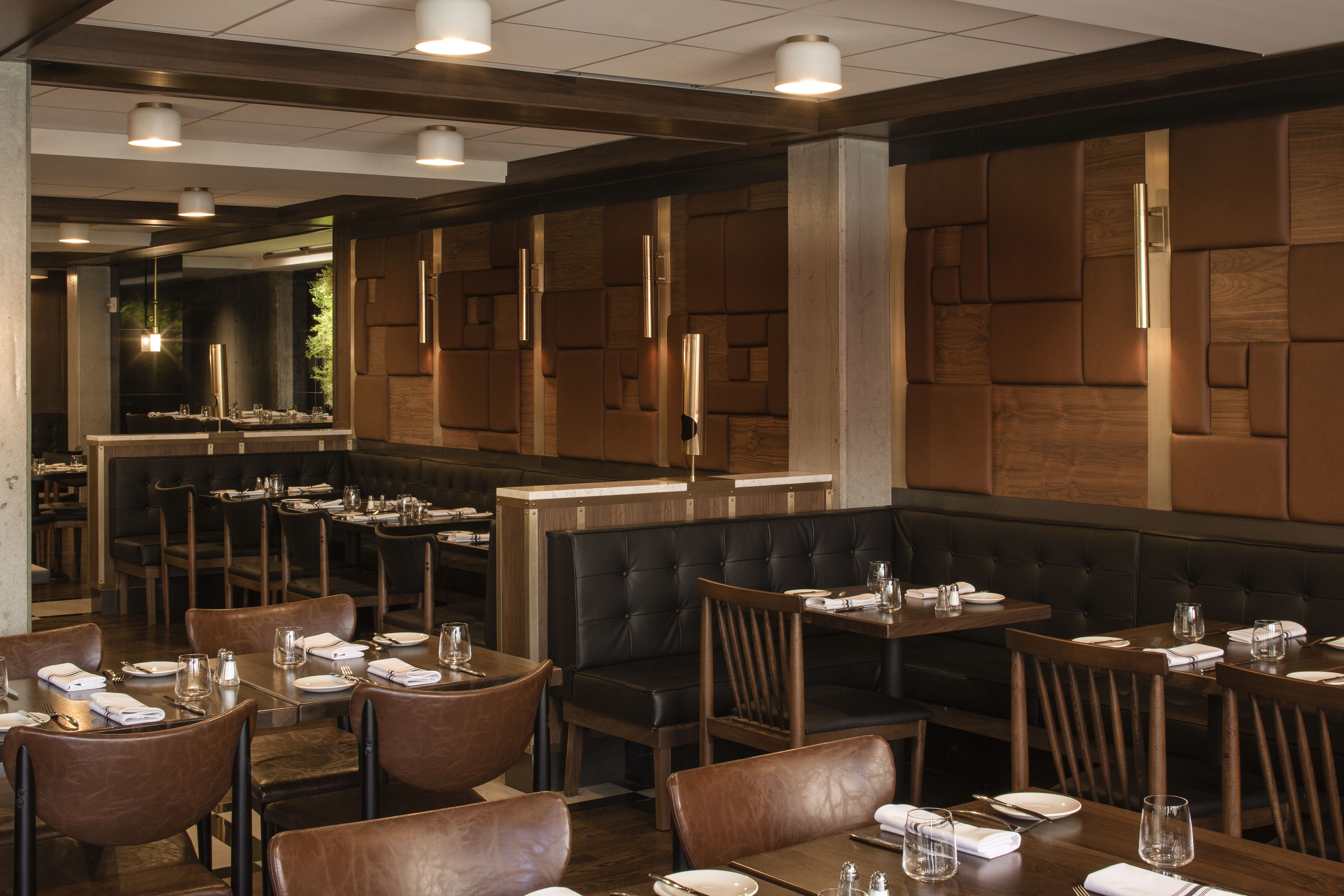 A restaurant interior with booth seating, tables, and a bar area.