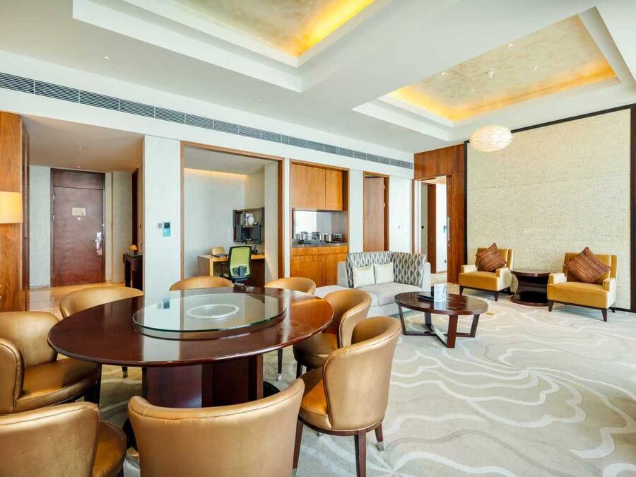 Habitación de hotel con comedor, un conjunto de sofás y una kitchenette.