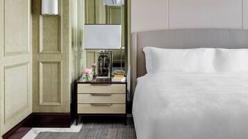 A hotel room with a large bed, a bedside table with a lamp, a mirror, and a dresser.
