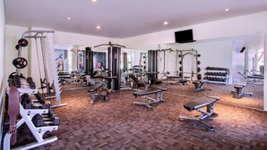 A gym with various exercise equipment, including dumbbells, benches, and weight machines.