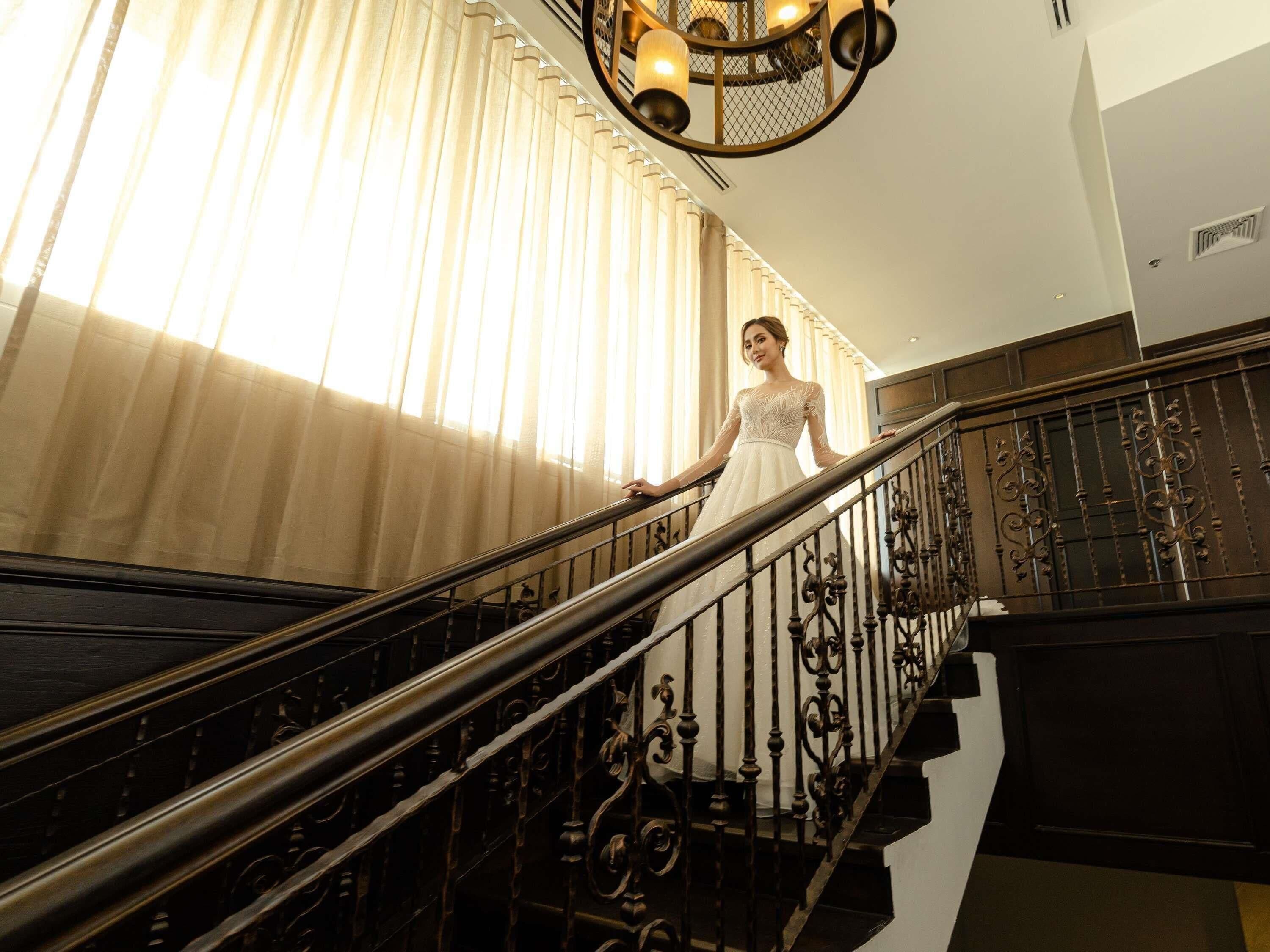 A staircase with ornate metal railings and a chandelier.