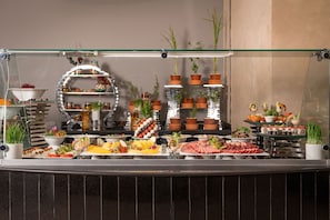 A buffet with various food items and potted plants. - Steigenberger Hotel El Tahrir Cairo (Cairo)