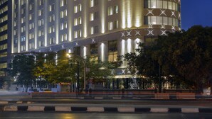 A large, illuminated hotel with a curved facade and a prominent sign at the top. - Steigenberger Hotel El Tahrir Cairo (Cairo)