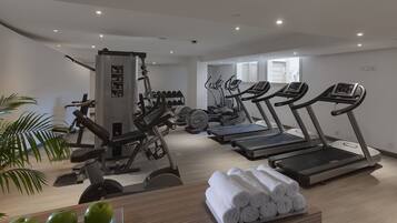 A modern gym with treadmills, weight machines, and dumbbells.