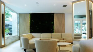 Un área de estar moderna con un sofá modular, sillones y una mesa de centro.