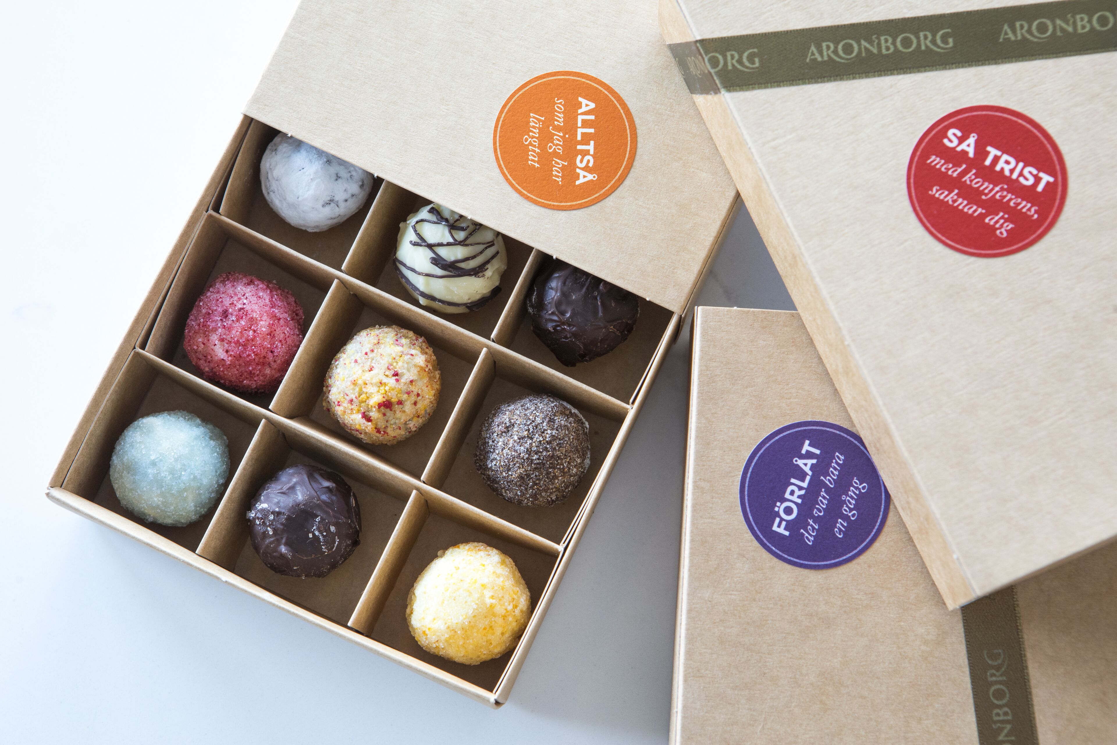 Uma caixa de chocolates variados com etiquetas de marca visíveis.