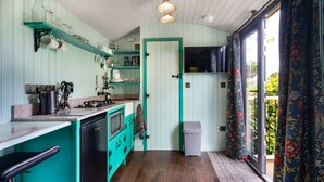 Une cuisine dotée de meubles de couleur turquoise, d’un lave-vaisselle et d’un plan de travail sur lequel se trouvent divers appareils électroménagers.