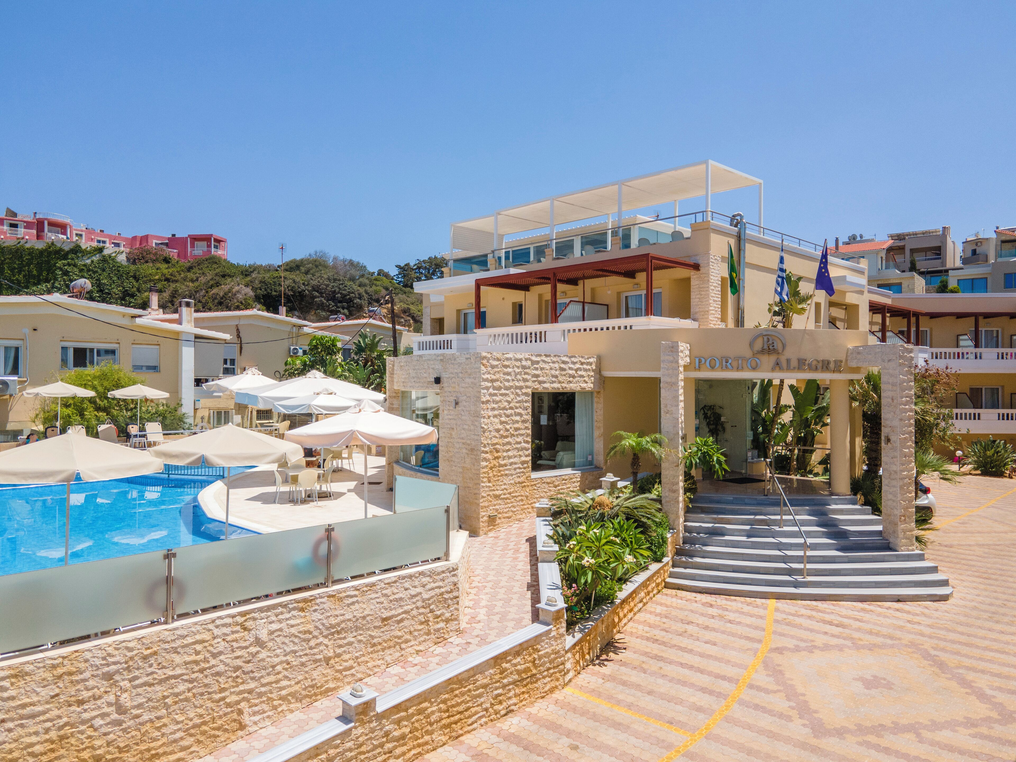 A hotel with a pool, outdoor seating, and a stone facade.