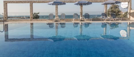 Piscine extérieure, parasols de plage, chaises longues