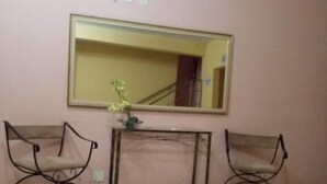 A room with two chairs, a small table, and a mirror on the wall.