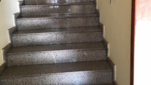A staircase with a handrail on both sides, leading to an upper floor.