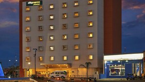 A CityExpress Junior hotel with multiple floors, a well-lit entrance, and a visible parking area. - City Express Junior by Marriott Aguascalientes Centro (Aguascalientes)