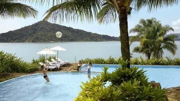 Een buitenzwembad, parasols voor strand/zwembad