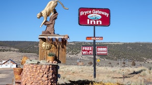 Une enseigne indiquant l’emplacement du Bryce Gateway Inn, avec une statue de lion, un accès Wi-Fi gratuit et un panneau indiquant qu’il y a des chambres disponibles.