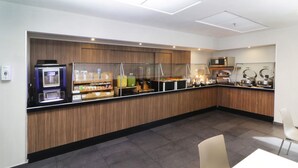 A modern breakfast bar with a coffee machine, juice dispenser, and various food items. - City Express by Marriott Piedras Negras (Piedras Negras)