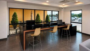 A modern office space with a long table, two chairs, and a laptop. - City Express by Marriott Piedras Negras (Piedras Negras)